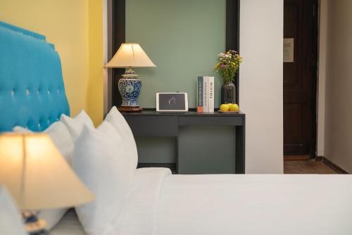 a bedroom with a bed and a table with a lamp at Little Hanoi Old Quarter Hostel in Hanoi