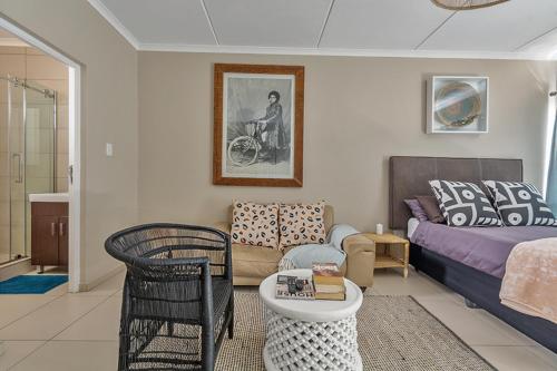 a living room with a couch and a table at Modern Heritage Condo in Fourways