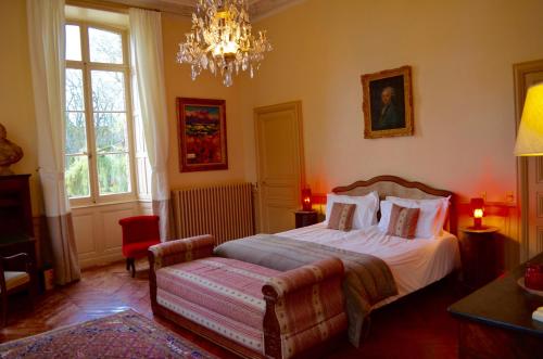 a bedroom with a bed and a chandelier at Domaine de Vauluisant in Courgenay