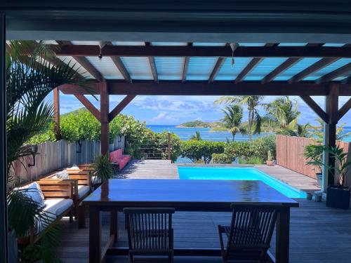 Un patio con mesa y sillas y una piscina. en Villa Pandora, en Cul de Sac