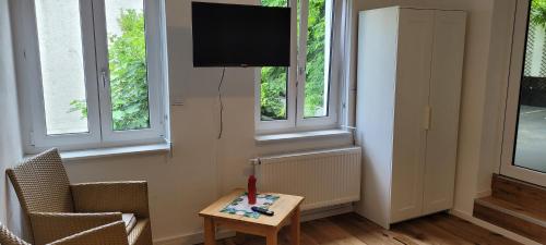 a living room with a tv and a table and windows at Ferienwohnung mit großer Terrasse in Boppard