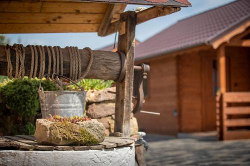 a bird bath with a bucket in front of a house at Kövirózsa Vendégház in Cserépfalu