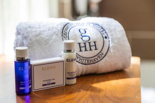 a table with two bottles of essential oils and a towel at Georgian House Hotel in Whitehaven