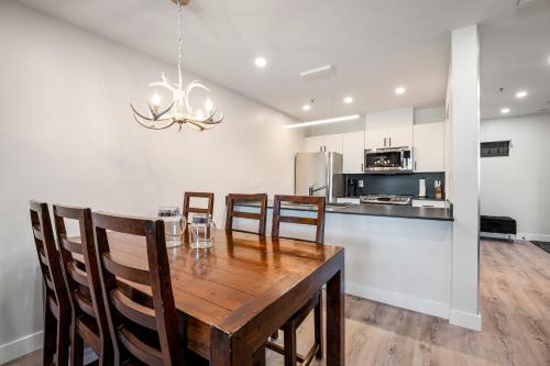 a kitchen and dining room with a wooden table and chairs at Ski In & Out, Heart of Upper Village, Pool & Hot Tub in Whistler