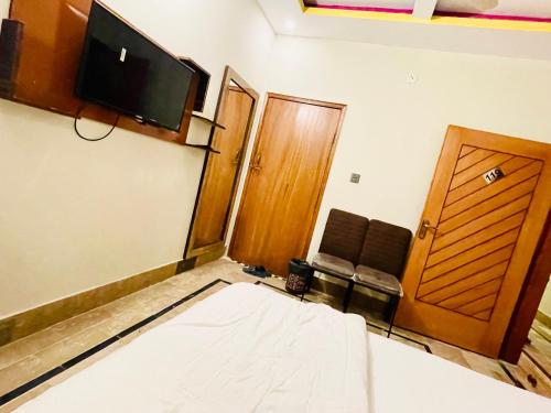 a room with a bed and a flat screen tv at Airport Hotel Bed & Rest in Karachi