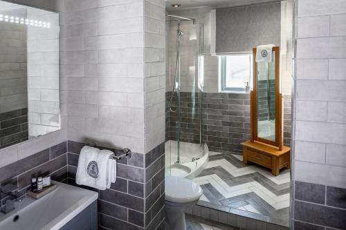 a bathroom with a toilet and a shower and a sink at Georgian House Hotel in Whitehaven