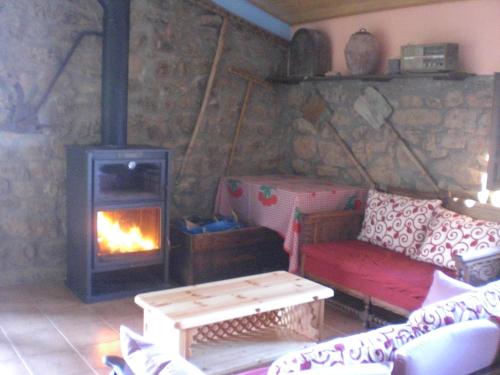 a room with a fireplace and a couch and a stove at El Pajar in Castilsabás