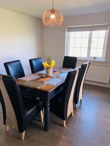 a dining room table with black chairs and a tableablish at Valley Lodge 3 BR Retreat in Craigantlet Hills in Belfast