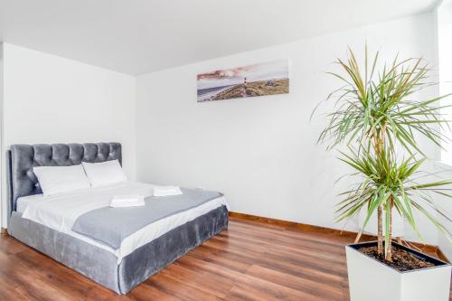 a bedroom with a bed and two potted plants at MALŪNO Calm Getaway SELF CHECK-IN in Klaipėda