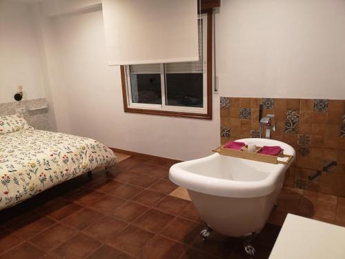 a bathroom with a sink and a bed at Casa con piscina y jacuzzi in Pontevedra