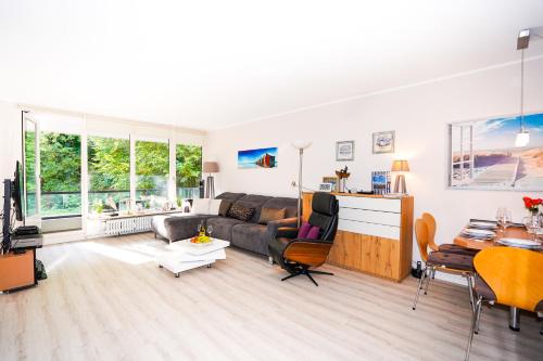 a living room with a couch and a table at Seglernest 204, strandnahe Fewo mit Schwimmbad und Sauna in Timmendorfer Strand