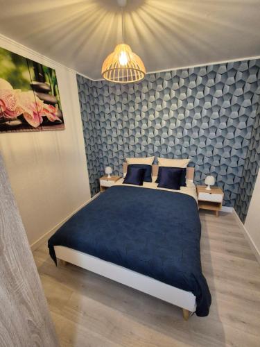 une chambre avec un grand lit avec une couverture bleue dans l'établissement Bel appartement proche Paris, à Puteaux