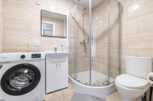a bathroom with a washing machine and a toilet at MALŪNO Calm Getaway SELF CHECK-IN in Klaipėda