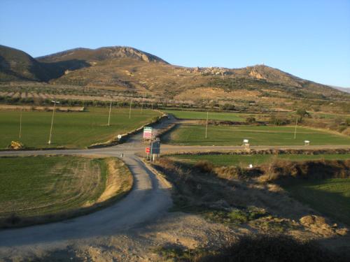 a winding road in a field with mountains in the background at El Pajar in Castilsabás