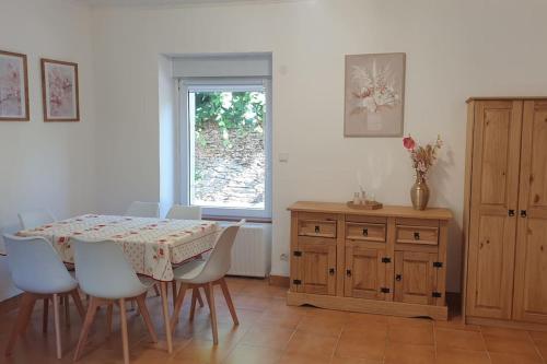 une salle à manger avec une table et des chaises et une fenêtre dans l'établissement La Maison Fleurie, à Josselin
