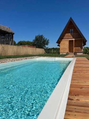 a swimming pool with a house in the background at Kućica naša bajka in Kupinovo