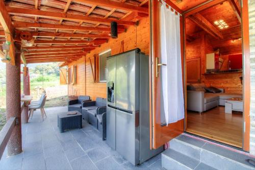 un grand réfrigérateur en métal sur le porche d'une maison dans l'établissement Maison en bois village entre montagne et mer, à Sari-dʼOrcino