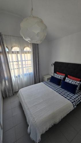 sypialnia z dużym łóżkiem z niebieskimi i czerwonymi poduszkami w obiekcie Fuerte Holiday M&M Apartaments w mieście Costa Calma