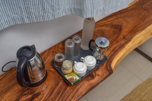 a tray with a tea kettle and other items on a table at Badolina Bungalows in Nungwi