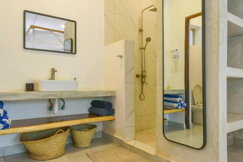 a bathroom with a shower and a sink at Badolina Bungalows in Nungwi