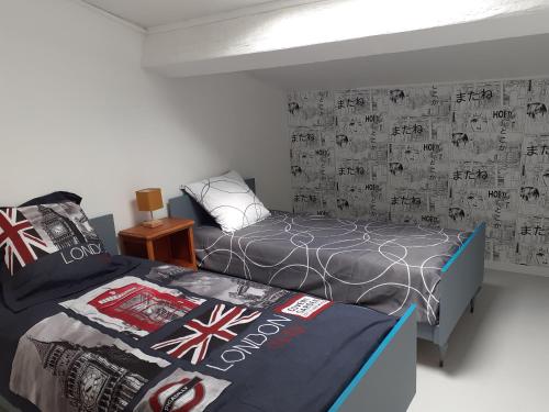 - une chambre avec 2 lits et un mur avec un bureau dans l'établissement Le petit Gîte de France, à Libourne