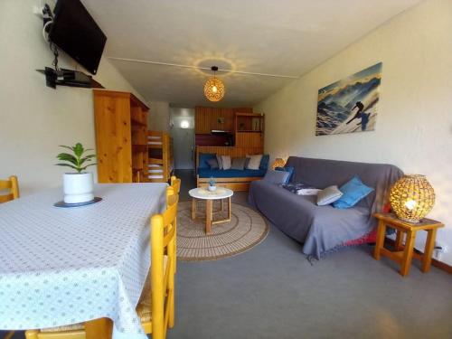 un soggiorno con un divano blu e un tavolo di Charmant Studio Le Lioran - Tour Sumène a Laveissière