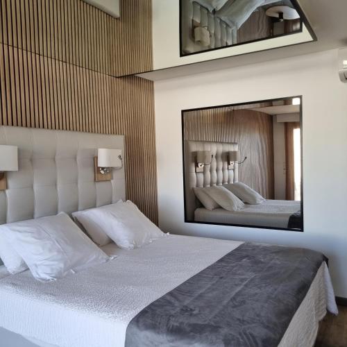 - une chambre avec un grand miroir au-dessus d'un lit dans l'établissement Studio Naturiste Adam Résidence Le Jardin D'Eden, au Cap d'Agde