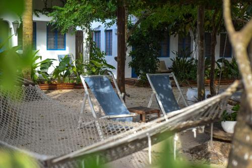 three chairs sitting in a hammock in a yard at Badolina Bungalows in Nungwi
