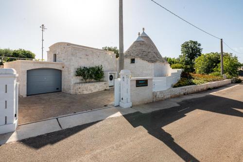 a brick house with a garage and a driveway at Resort Trulli San Leonardo in Alberobello
