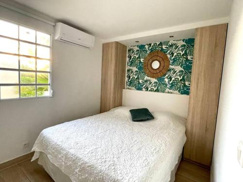 a bedroom with a white bed and a mirror on the wall at Côté Mer Wonderfull 2 bedrooms beachfront Nettle bay Beach Club in Baie Nettle