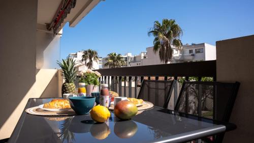 une table en verre avec des fruits sur un balcon avec vue dans l'établissement Charmant et cosy, à 100m de la plage avec terrasse, à Cannes