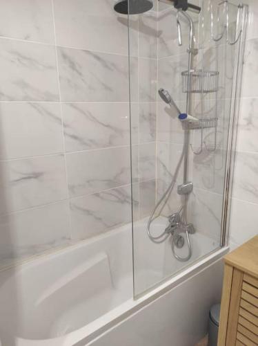 d'une douche avec une porte en verre à côté d'une baignoire. dans l'établissement Charmant T2 avec vue sur l'étang, à Sète