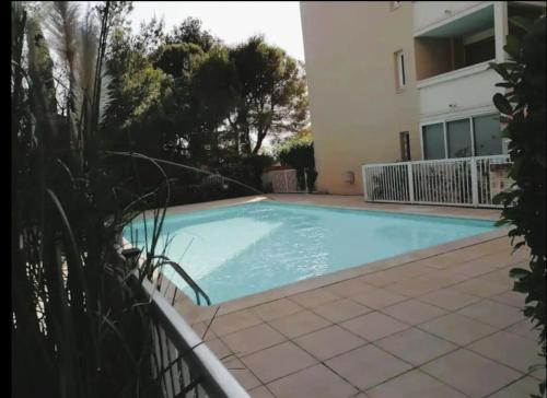 une piscine devant une maison dans l'établissement Charmant T2 avec vue sur l'étang, à Sète