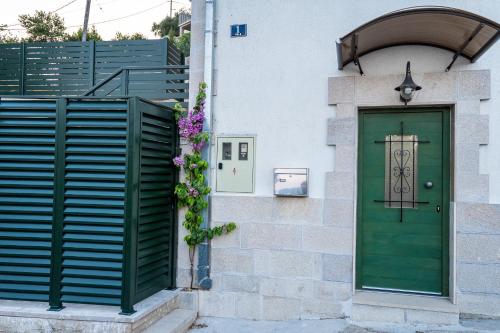 a green door on the side of a building at Holiday House Boban with Private Pool and Garage in Mimice