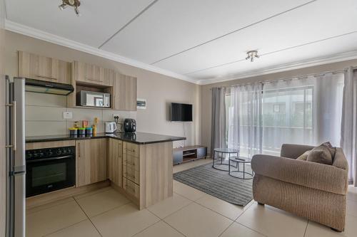 a kitchen and living room with a couch and a chair at 1 Bed in Chartwell in Chartwell