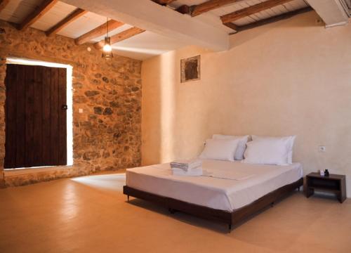 a bedroom with a bed in a room with a brick wall at Villa Oraia Verga Kalamata in Kalamata