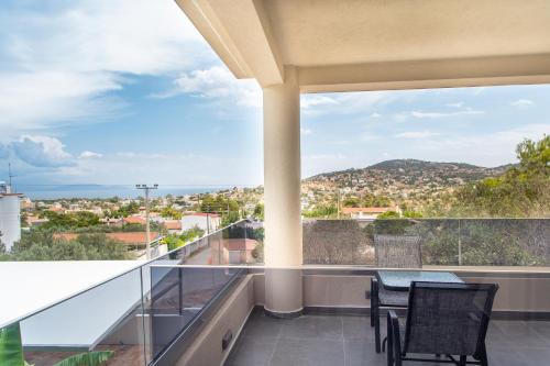 a balcony with a table and chairs and a view at Airscape Hotel Free Shuttle From And To Athen's Airport in Artemida