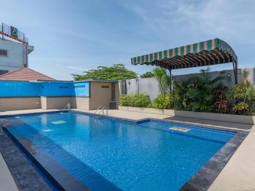 a swimming pool in front of a building at The Kanjeng Suites Kuta Galeria - Bali in Kuta