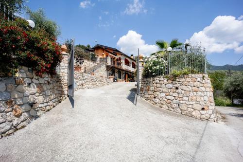 a stone fence with a gate in front of a house at LA TAVERNA tra gli ulivi in Perinaldo
