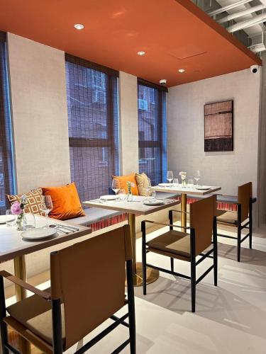 a dining room with tables and chairs and windows at Mia Hotel - Shanghai Shaanxi South Road in Shanghai