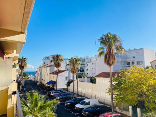 - une vue sur une rue bordée de palmiers et de voitures dans l'établissement Charmant et cosy, à 100m de la plage avec terrasse, à Cannes