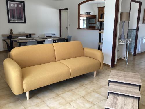 un salon avec un canapé jaune et une table dans l'établissement Villa Nine, à Bessan