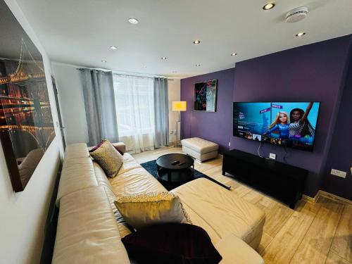 a living room with a couch and a flat screen tv at Strelley house 2 , Perfect for business trip & Families holiday or working proffesionals-5 min from M1 J25 , 500MB Wi-Fi , Netflix , Fully equiped kitchen , Asda supermarket 5 min walk , Free Secure parking with CCTV ,available monthly deals in Nottingham
