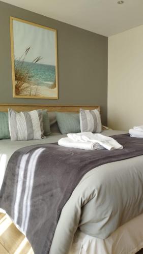 a bedroom with a large bed with a picture on the wall at Hostería Antu Kuyen in San Carlos de Bariloche