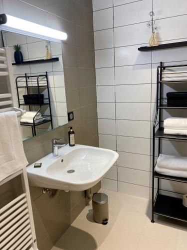 une salle de bain avec un lavabo, un miroir et des serviettes dans l'établissement Hôtel Au Château, à Villers-lès-Nancy