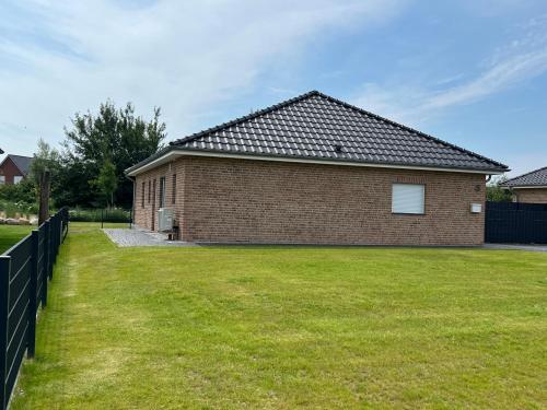 a brick house with a grass yard at Ferienhaus RELAX in Büsum