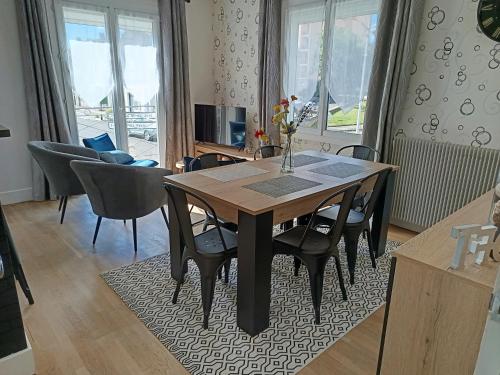 une salle à manger avec une table et des chaises en bois dans l'établissement Maison de ville 70m², à Champagnole