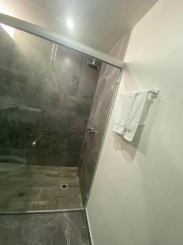 a bathroom with a shower and a towel on a wall at MID-498 Centro in Mérida