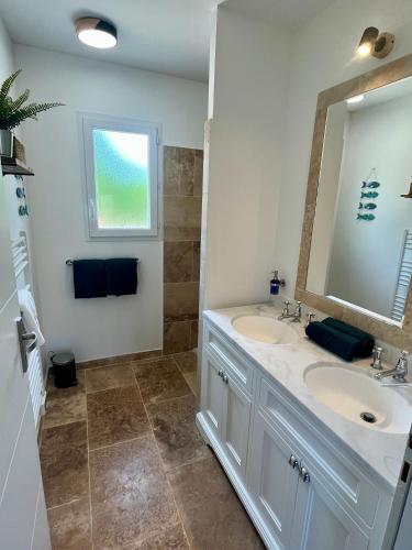 une salle de bain avec deux lavabos et un miroir dans l'établissement Le Clos de L'Oliveraie - Appartements de charme avec piscine proche d'Uzès, à Sagriès