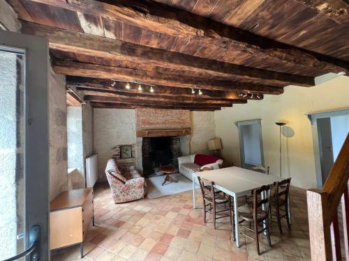 un salon avec une table et une cheminée dans l'établissement Les Gannes, à Saint-Paul